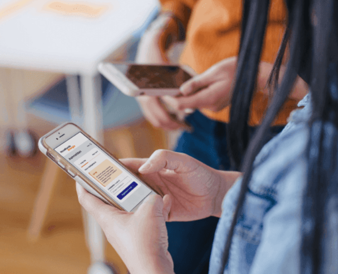 Persoon met telefoon waarop website noodfonds te zien is. 